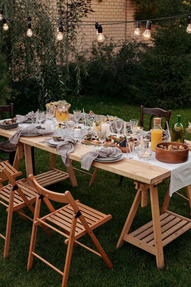 Outdoor dining table decorated for Thanksgiving with string lights